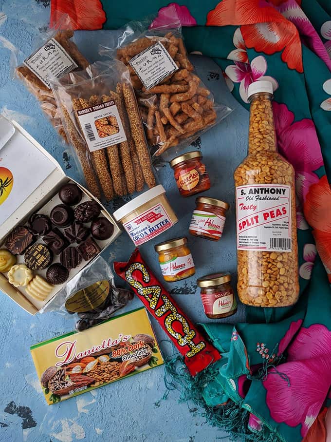 Chocolates, small jars of hot sauce, and packages snacks on a table.