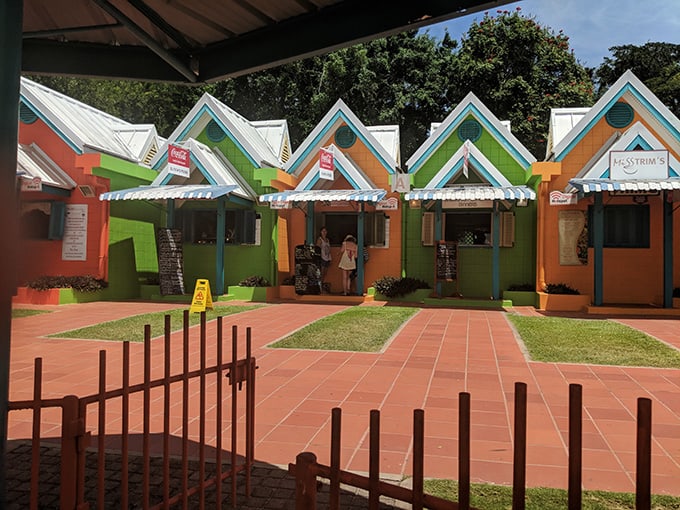 Small green and orange buildings with walk-up window restaurant fronts.