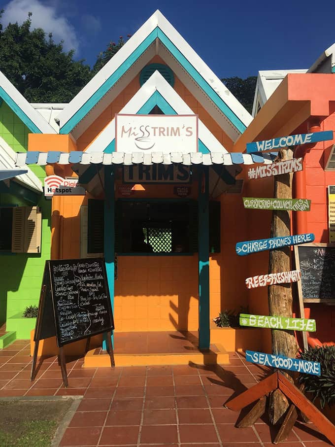 Restaurant front of an orange building with a menu sign.