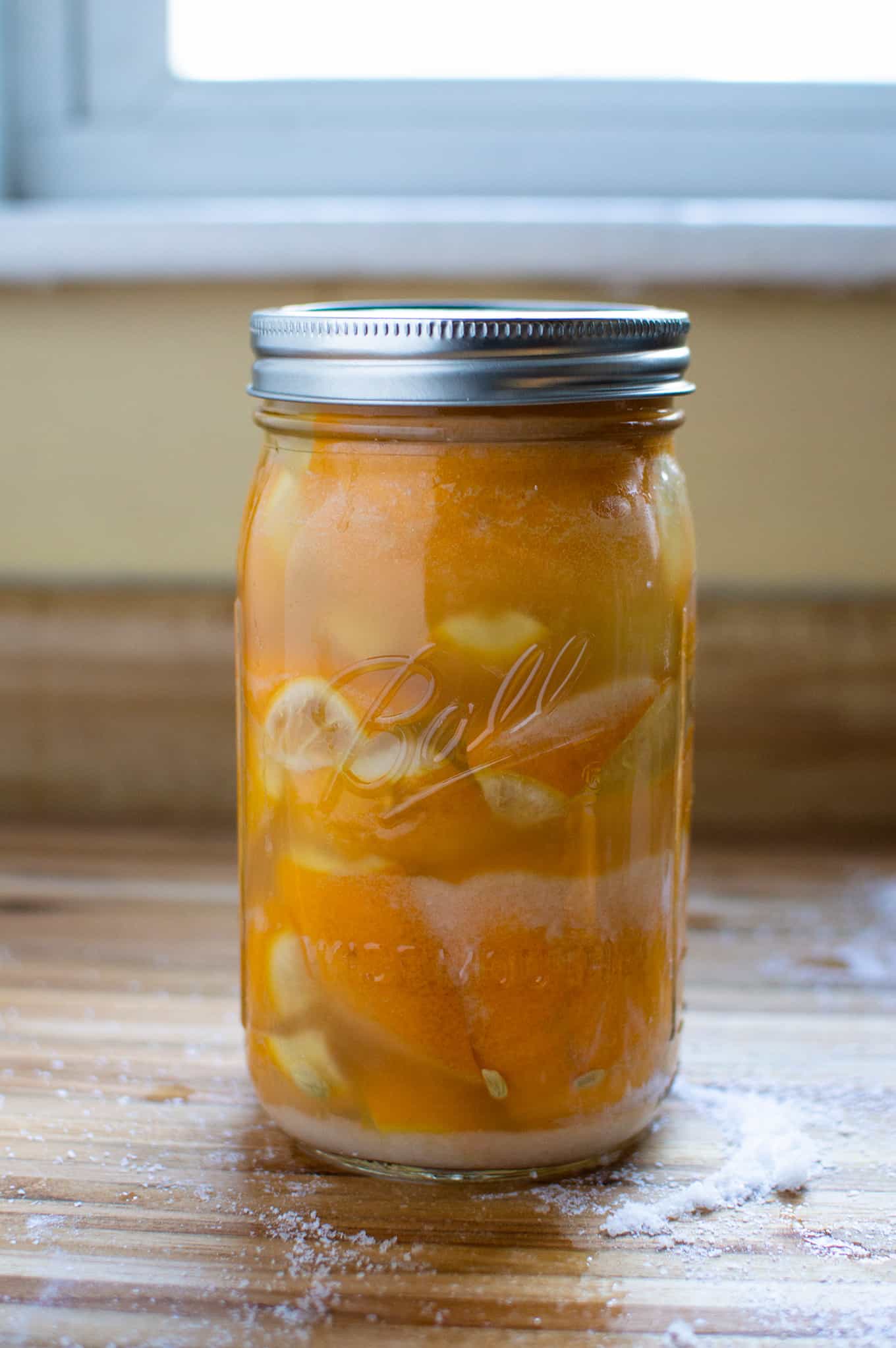 A mason jar of preserved lemons covered with a lid.