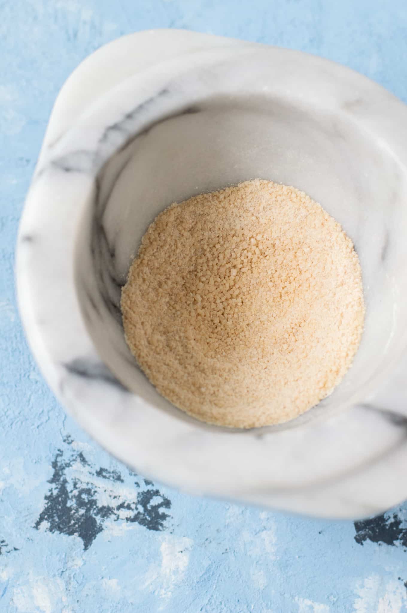 A close up of sugar in a marble bowl.