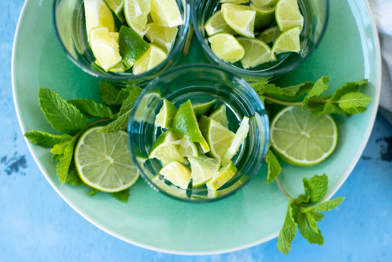 Close up of cut up limes in drinking glasses.