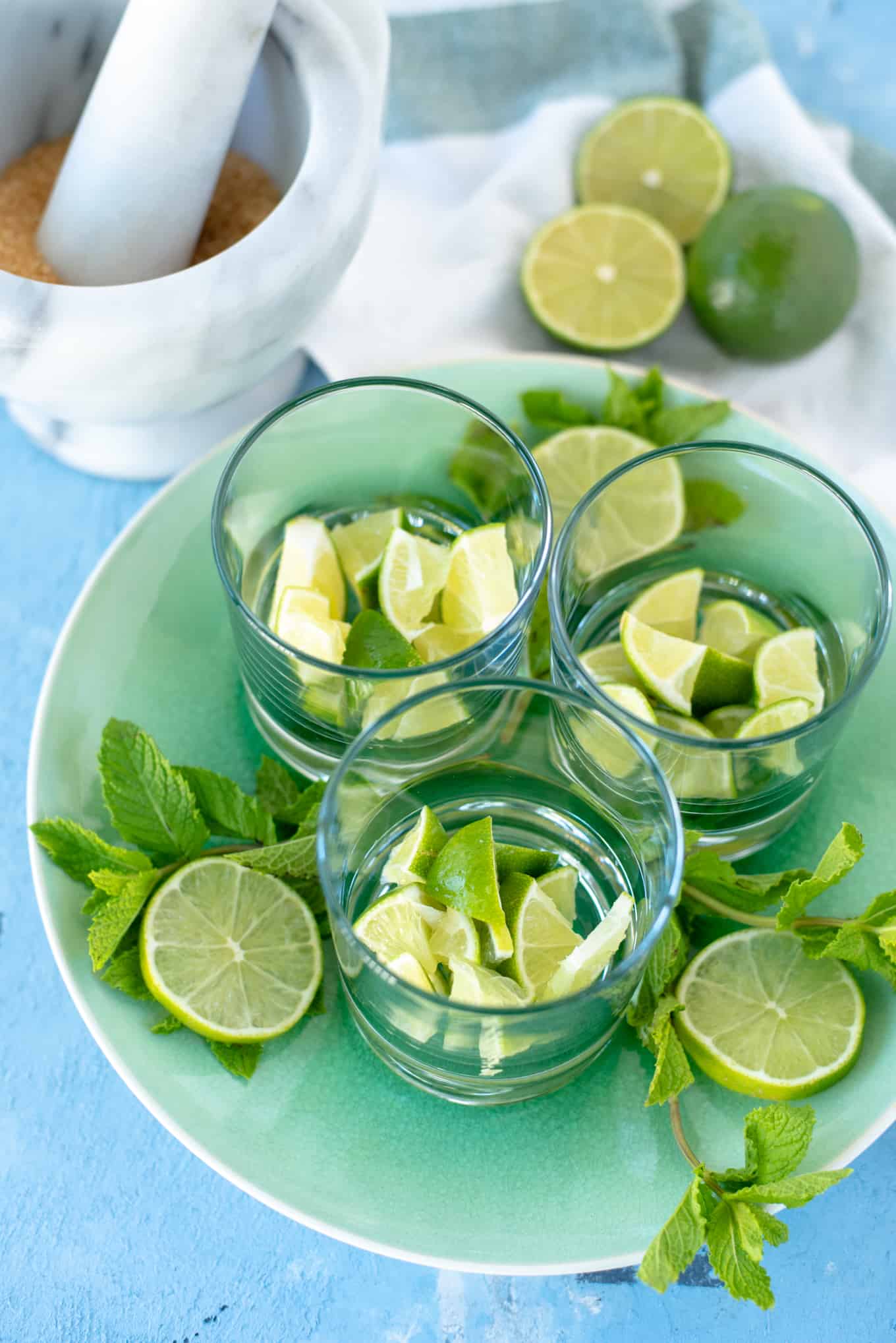 Three glasses on a small tray filled with cut-up limes.