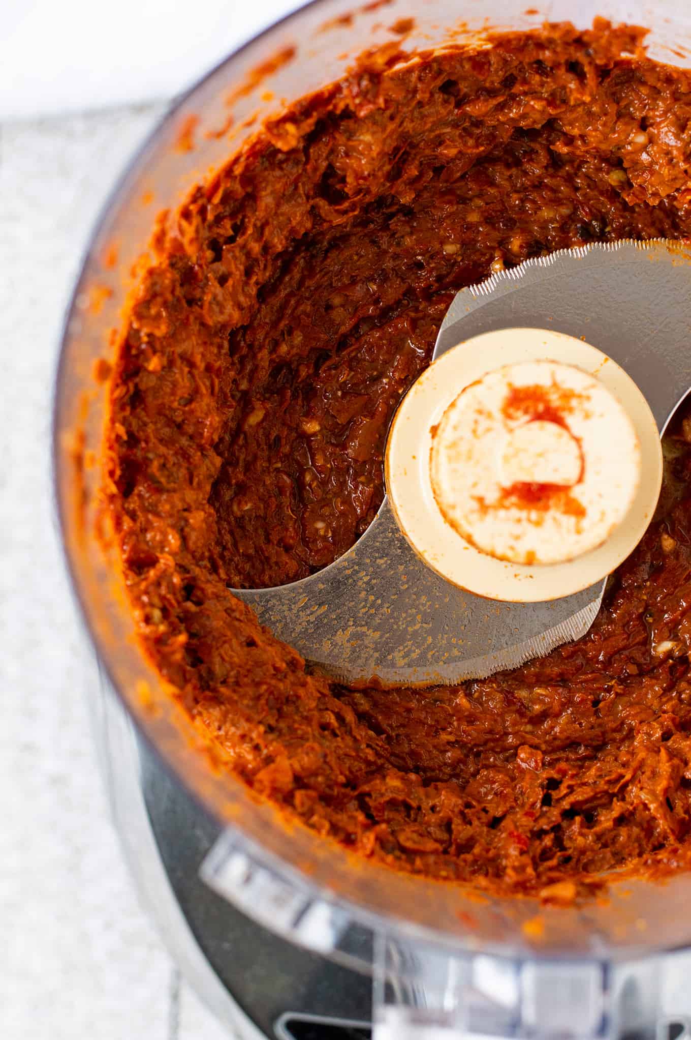 Close up of harissa pasta in a food processor.