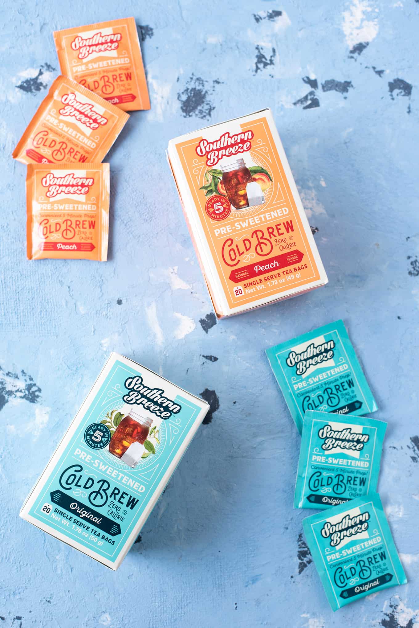 Assorted packaged cold brew tea bags and boxes displayed on a table.