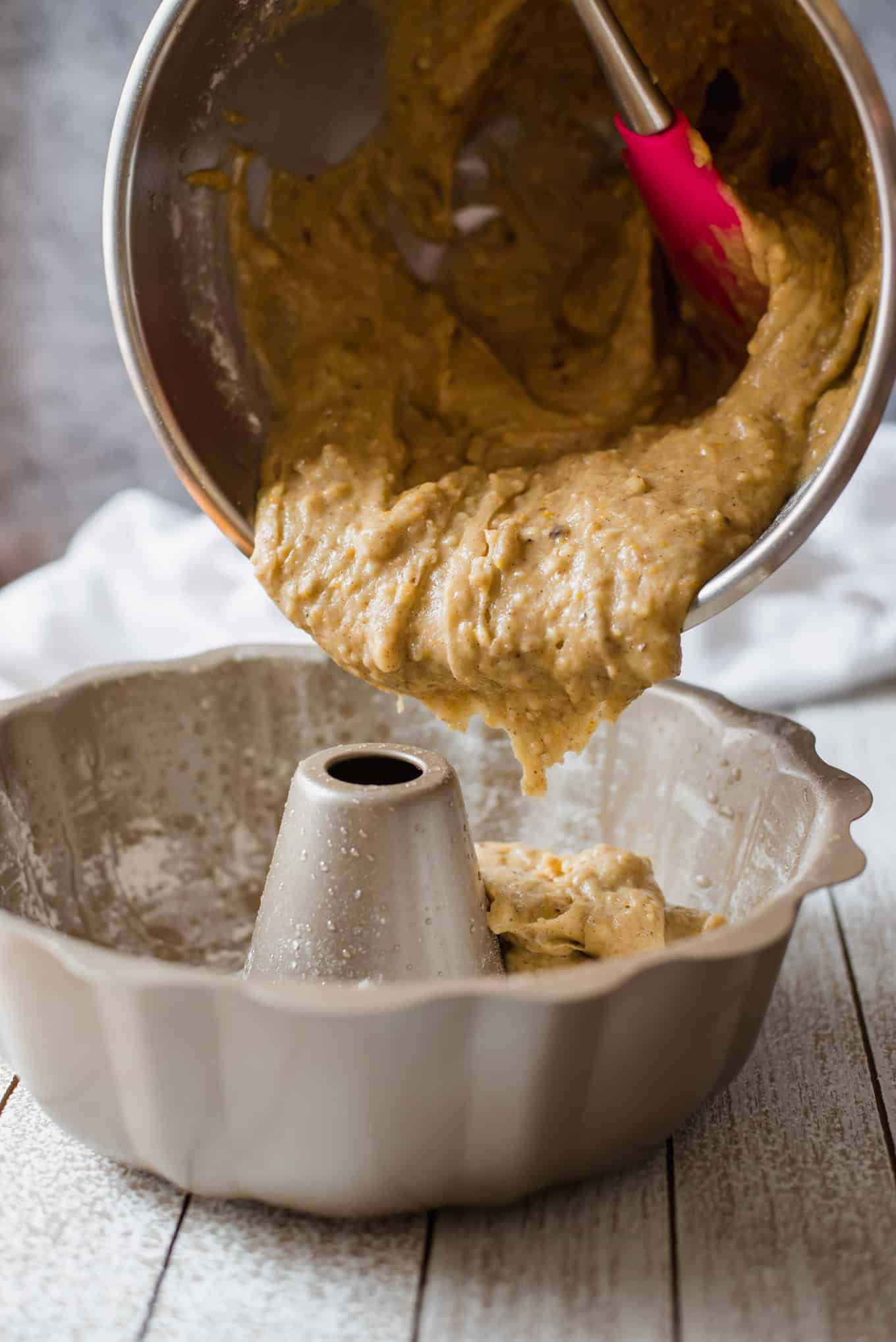 Fanouropita batter being poured into a bundt pan.