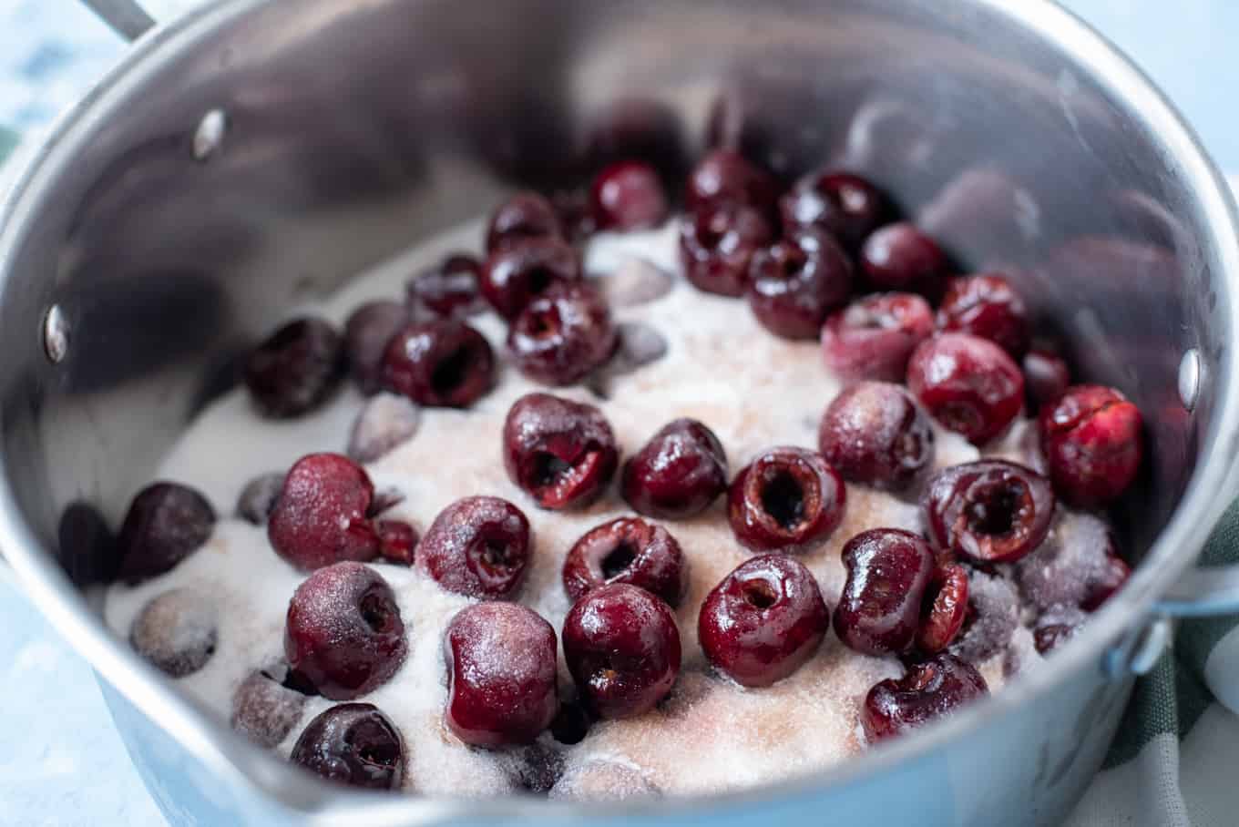 A bowl of pitted cherries mixed with sugar.