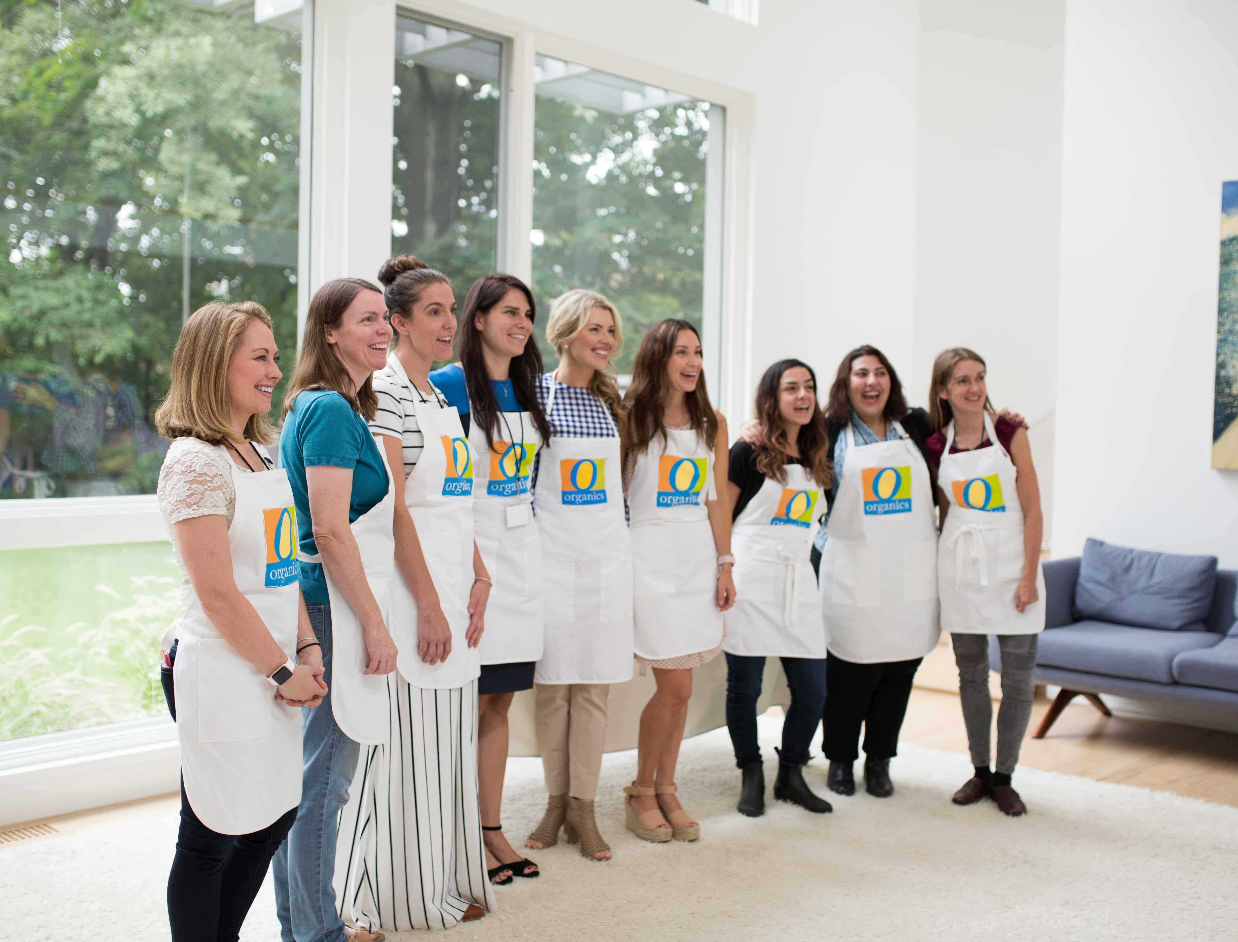 Women in matching aprons posing for a photo.