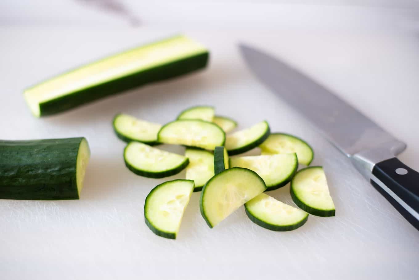 Sliced cucumber on a cutting board.