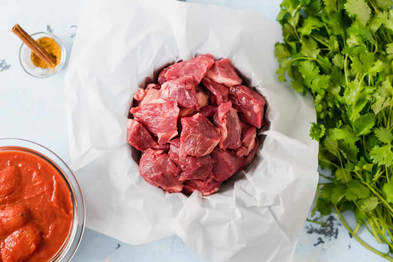 Raw lamb pieces in unwrapped butcher paper.