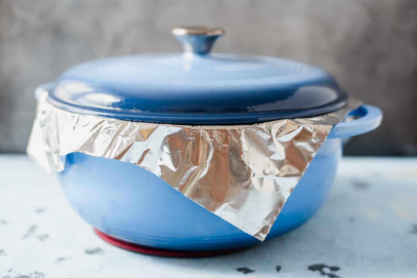A dutch oven lined with foil and topped with a lid.