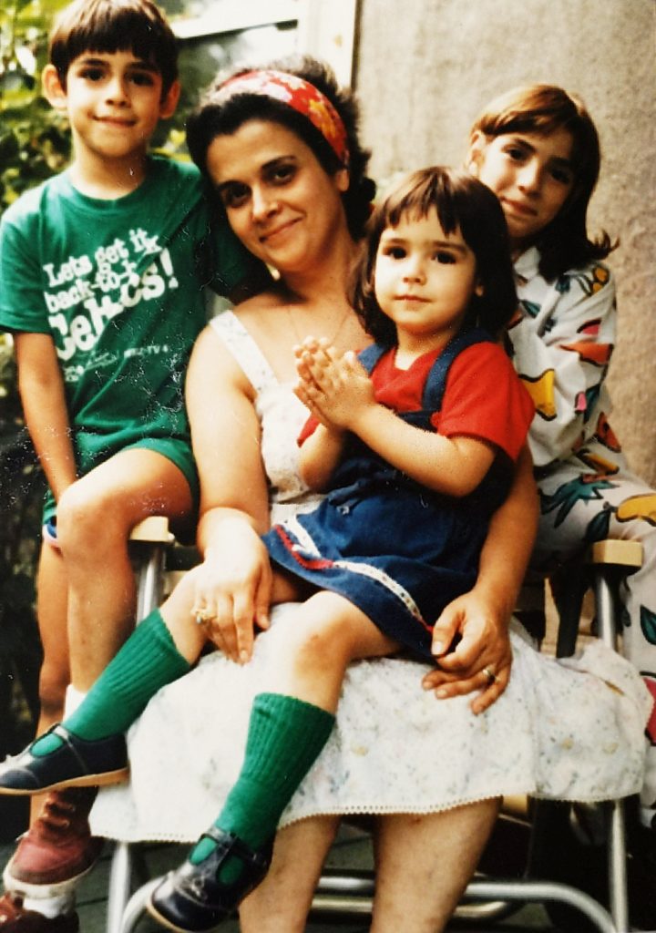 A group of young children sitting next to a woman.