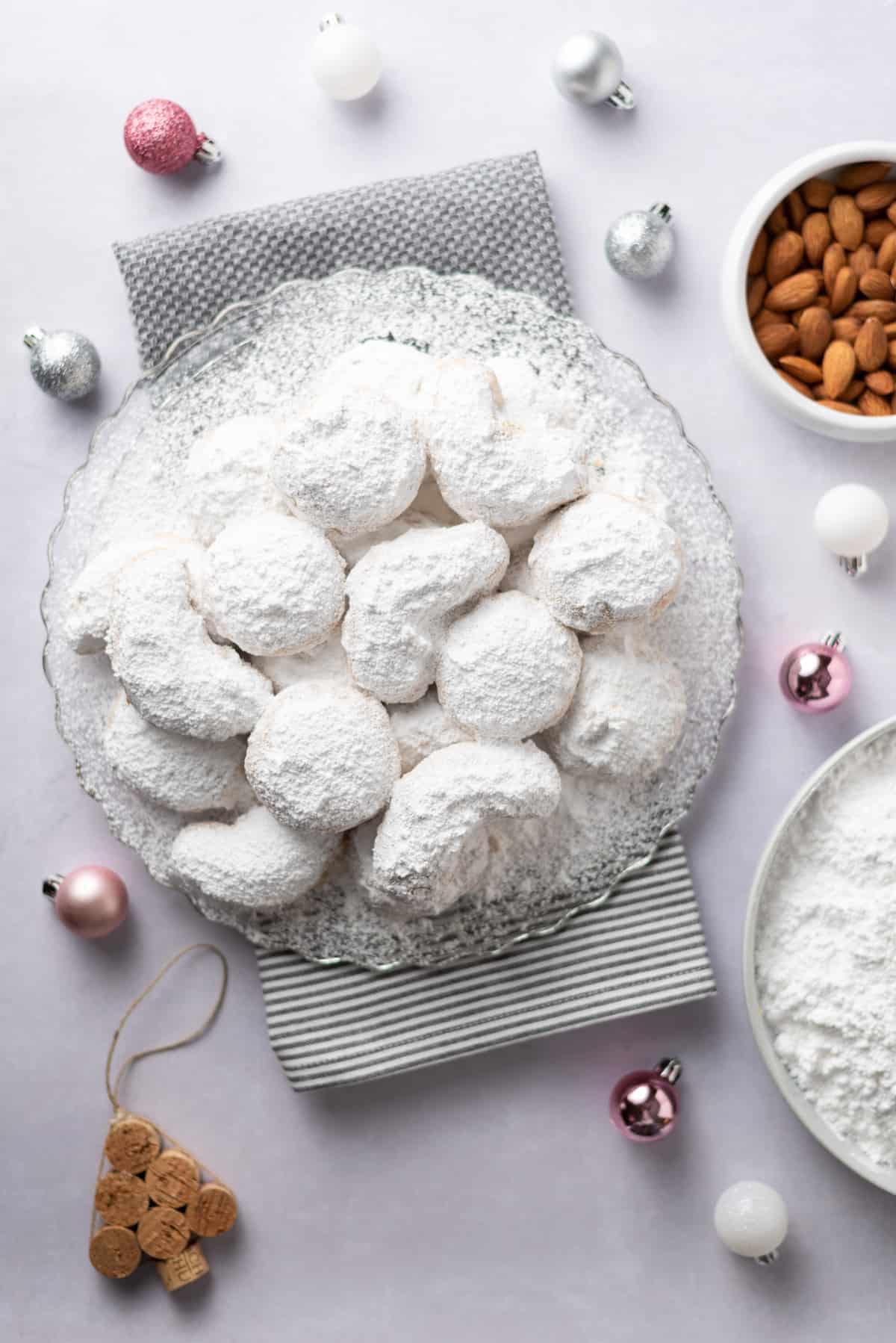 Top-down photo of a cookie platter and small Christmas ornaments on a tabletop.