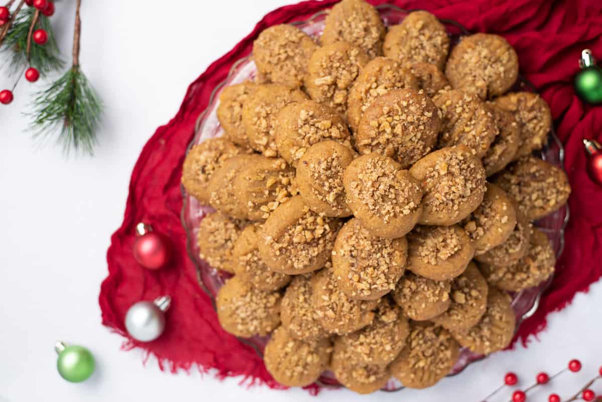 Closeup of a platter of Greek honey cookies and small ornaments on a tabletop.