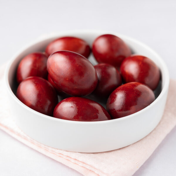 Featured image: a closeup of red-dyed eggs in a white bowl.