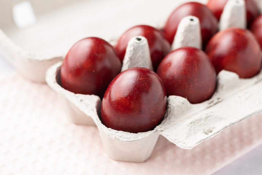 Red-dyed eggs in an egg carton.