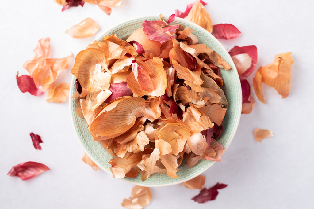 Yellow and red onion skins in a large bowl.