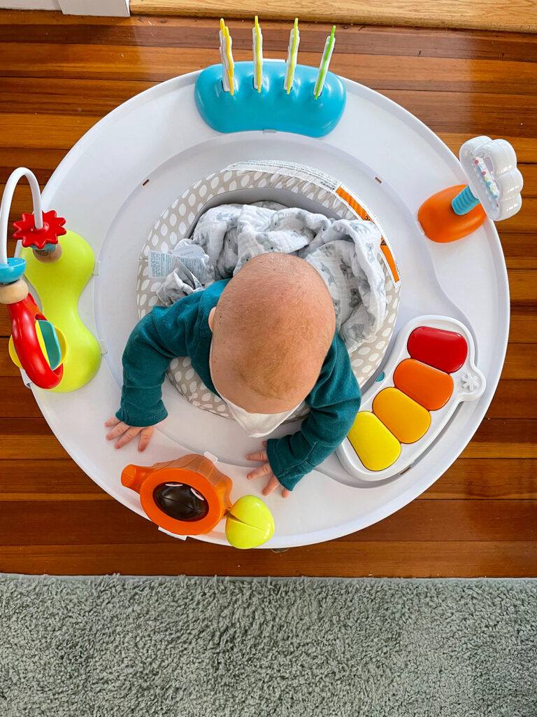 A baby playing in an activity center.