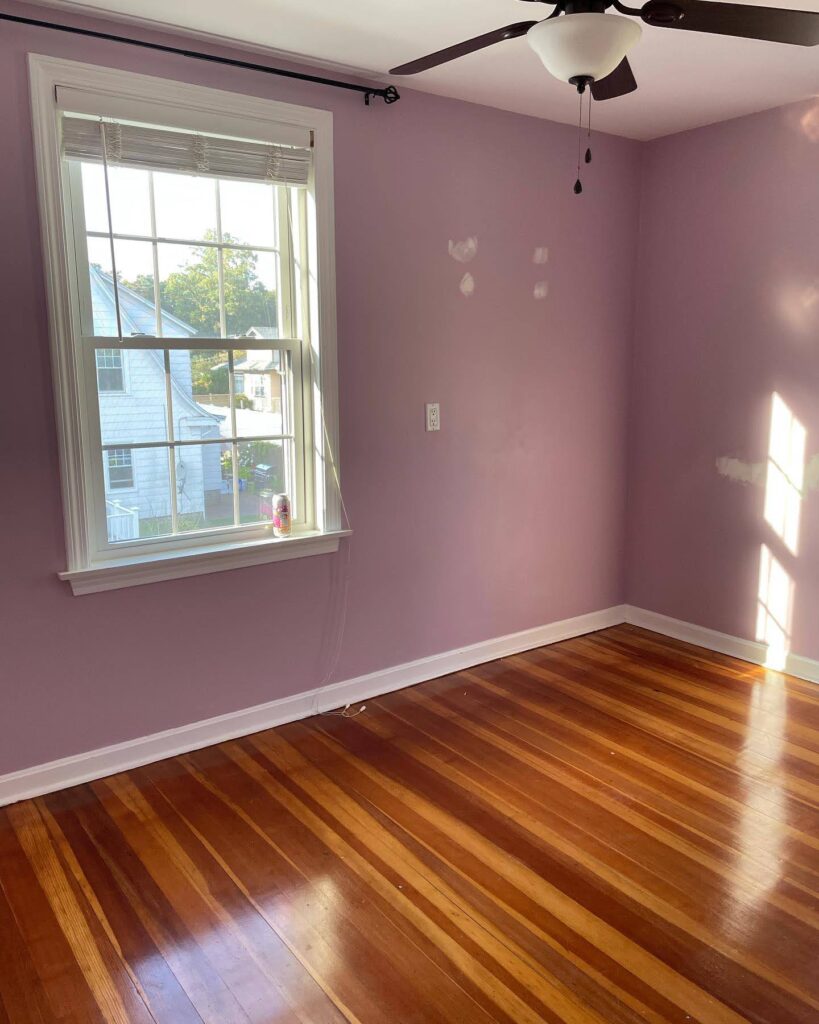 An empty bedroom with purple walls.