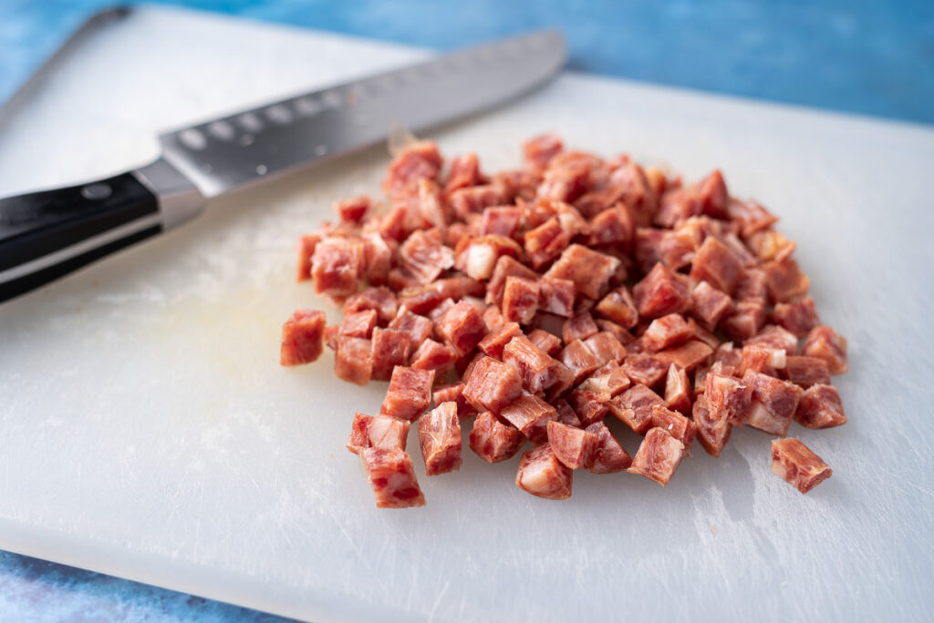 Chopped Chinese sausage on cutting board.